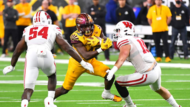 Wisconsin linebackers Jordan Turner and Nick Herbig tackle an Arizona State runner in the Las Vegas Bowl.